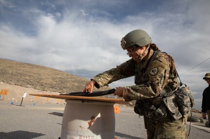 Staff Sgt. Sarah Hughes, with the Joint Forces Headquarters Battalion, loads a shell into the chamber of a M500 shotgun at the beginning stage of a three gun shoot during the Utah Best Warrior Competition held on Camp Williams, Utah, Nov. 7, 2021.