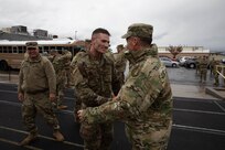 Spc. Spencer Fayles, a member of 97th Troop Command, shakes hands with senior leaders after finishing the ruck event during Utah's Best Warrior Competition