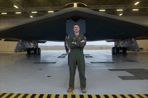 A photo of U.S. Air Force Capt. Kyle Cassady (right), 393rd Bomb Squadron B-2 Spirit instructor pilot, in front of a B-2 Spirit Stealth Bomber Dec. 28, 2021, at Whiteman Air Force Base, Missouri, next to a photo of his grandfather, Howard “Hopalong” Cassady, with the Heisman Trophy he won in 1955. Capt. Cassady is one of the pilots that will perform the B-2 flyover for the 108th Rose Bowl Game between The Ohio State Buckeyes and the University of Utah Utes. Cassady's father and grandfather both played for the Buckeyes and both won a Rose Bowl game during their football careers.  (U.S. Air Force graphic by Chelsea Ecklebe, using a courtesy photo and U.S. Air Force Photo by Tech. Sgt. Dylan Nuckolls)