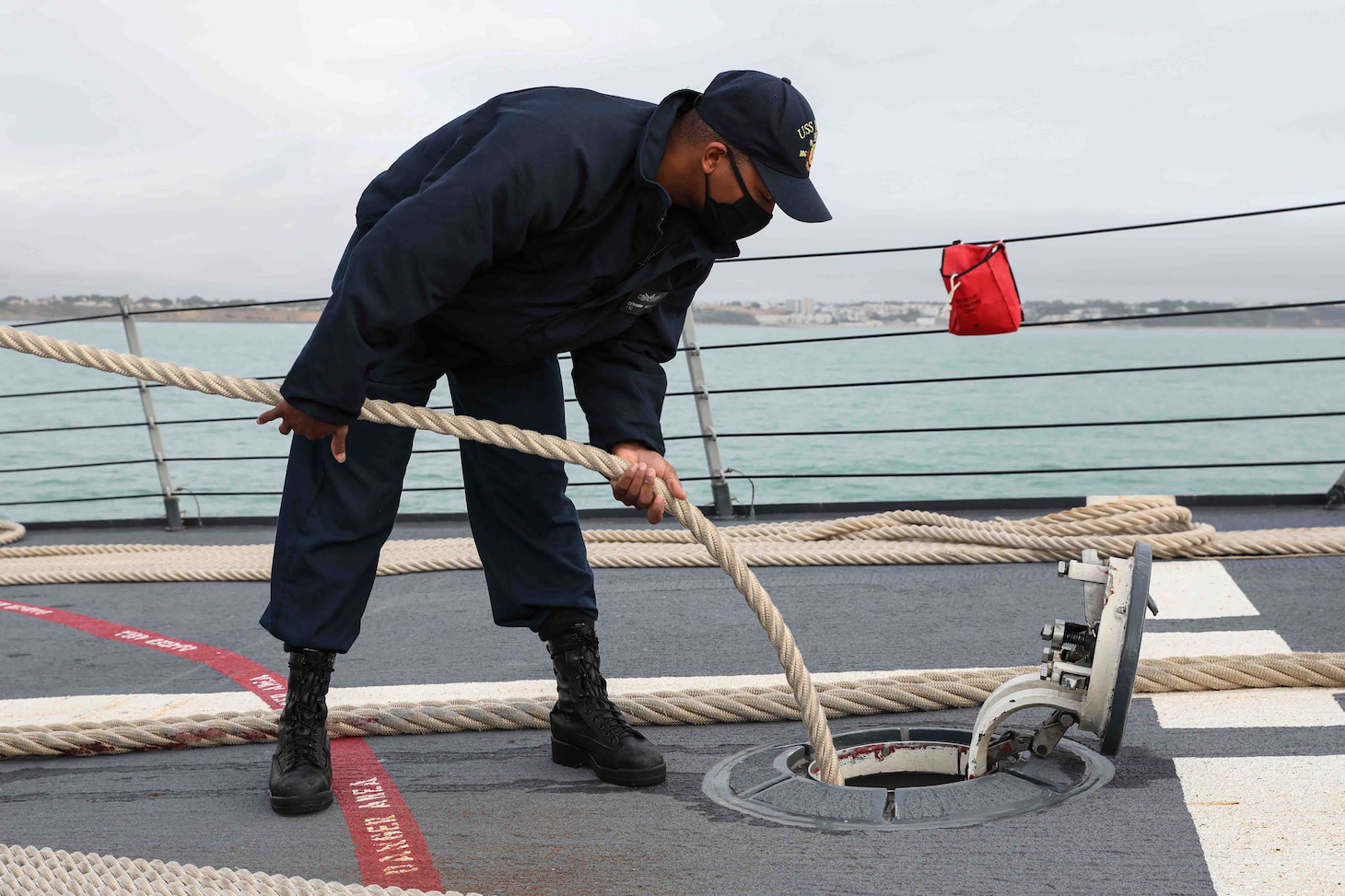 Personnel Specialist 2nd Class Deshawn McGowan, assigned to the Arleigh Burke-class guided-missile destroyer USS Ross (DDG 71), stows a mooring line as the ship leaves port at Naval Station Rota, Spain, Dec. 27, 2021. Ross, forward-deployed to Rota, Spain, is on its 12th patrol in the U.S. Sixth Fleet area of operations in support of regional allies and partners and U.S. national security interests in Europe and Africa. (U.S. Navy photo by Mass Communication Specialist 2nd Class Claire DuBois/Released)