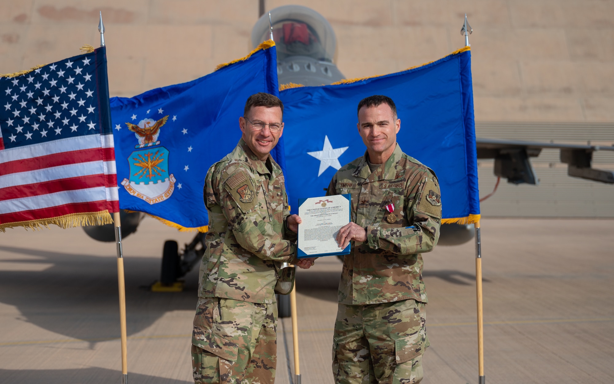 Col. Jason Smith, right, outgoing 378th Expeditionary Operations Group commander, receives the Meritorious Service Medal from Brig. Gen. Robert D. Davis, left, 378th Air Expeditionary Wing commander, during the 378th EOG change of command ceremony at Prince Sultan Air Base, Kingdom of Saudi Arabia, Dec. 26, 2021. The Meritorious Service Medal is awarded to members of the armed services who distinguish themselves by outstanding service to the United States. (U.S. Air Force photo by Staff Sgt. Christina Graves)