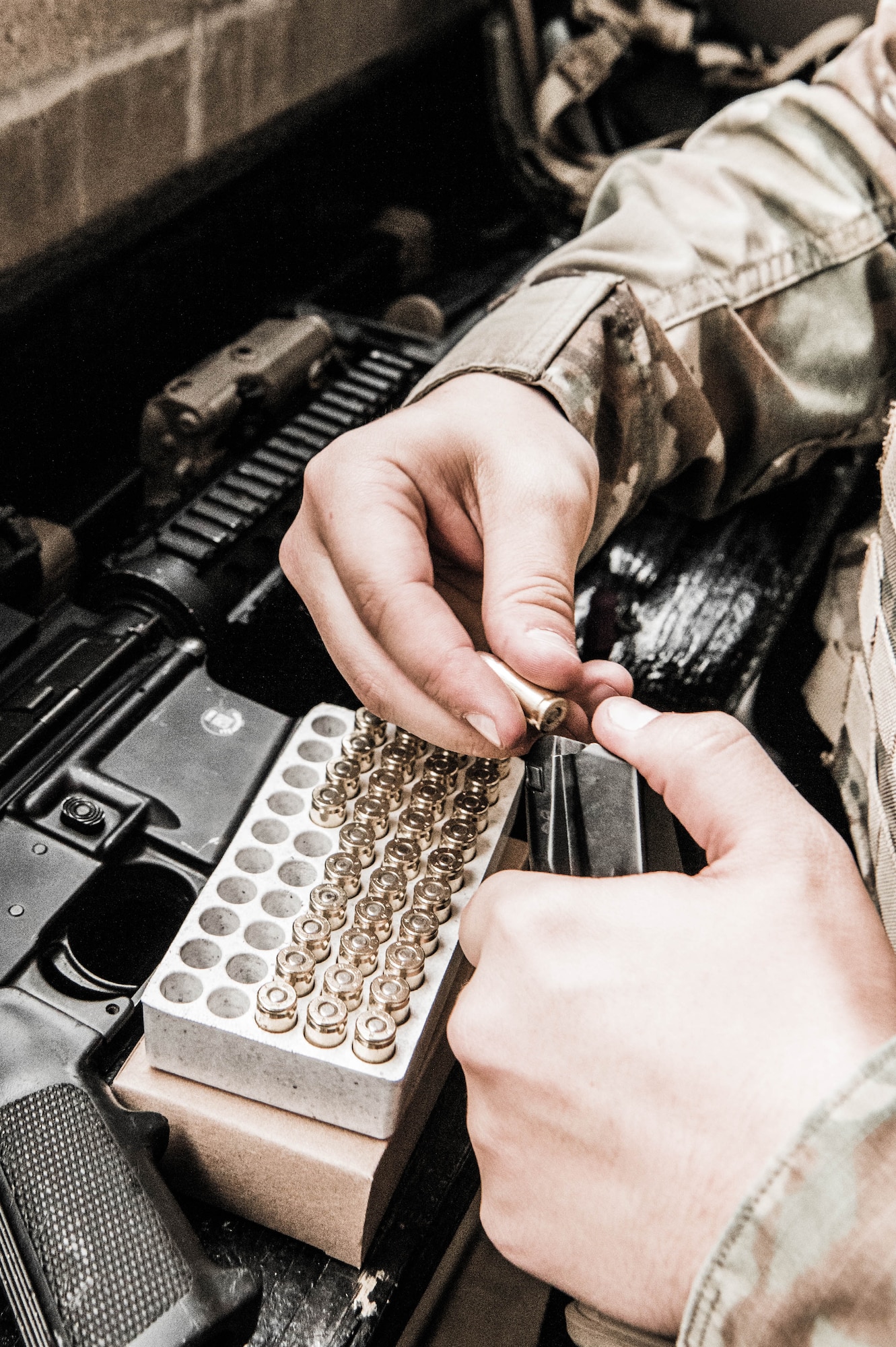 Senior Airman Troy Cramer, 436th Security Forces Squadron member, loads rounds of 9mm ammunition into a magazine before combat arms qualification Dec. 17, 2021, at Dover Air Force Base, Delaware. Each person receiving training is allotted an exact number of rounds to use during qualification. (U.S. Air Force photo by Mauricio Campino)