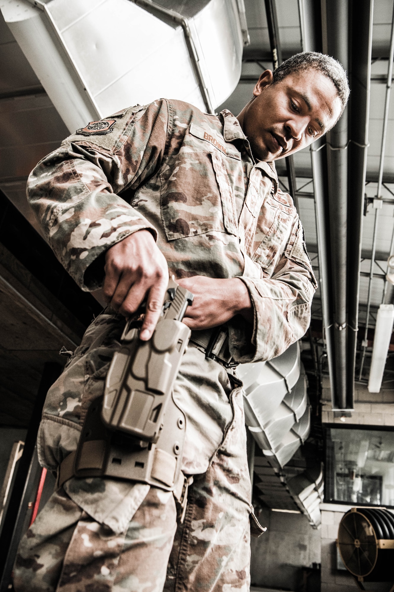 Master Sgt. Ritchie Brown, 436th Security Forces Squadron flight chief, secures his 9mm pistol to a tactical holster before combat arms qualification Dec. 17, 2021, at Dover Air Force Base, Delaware. Each member of the 436th SFS qualifies annually with an M4 carbine and a 9mm pistol. (U.S. Air Force photo by Mauricio Campino)