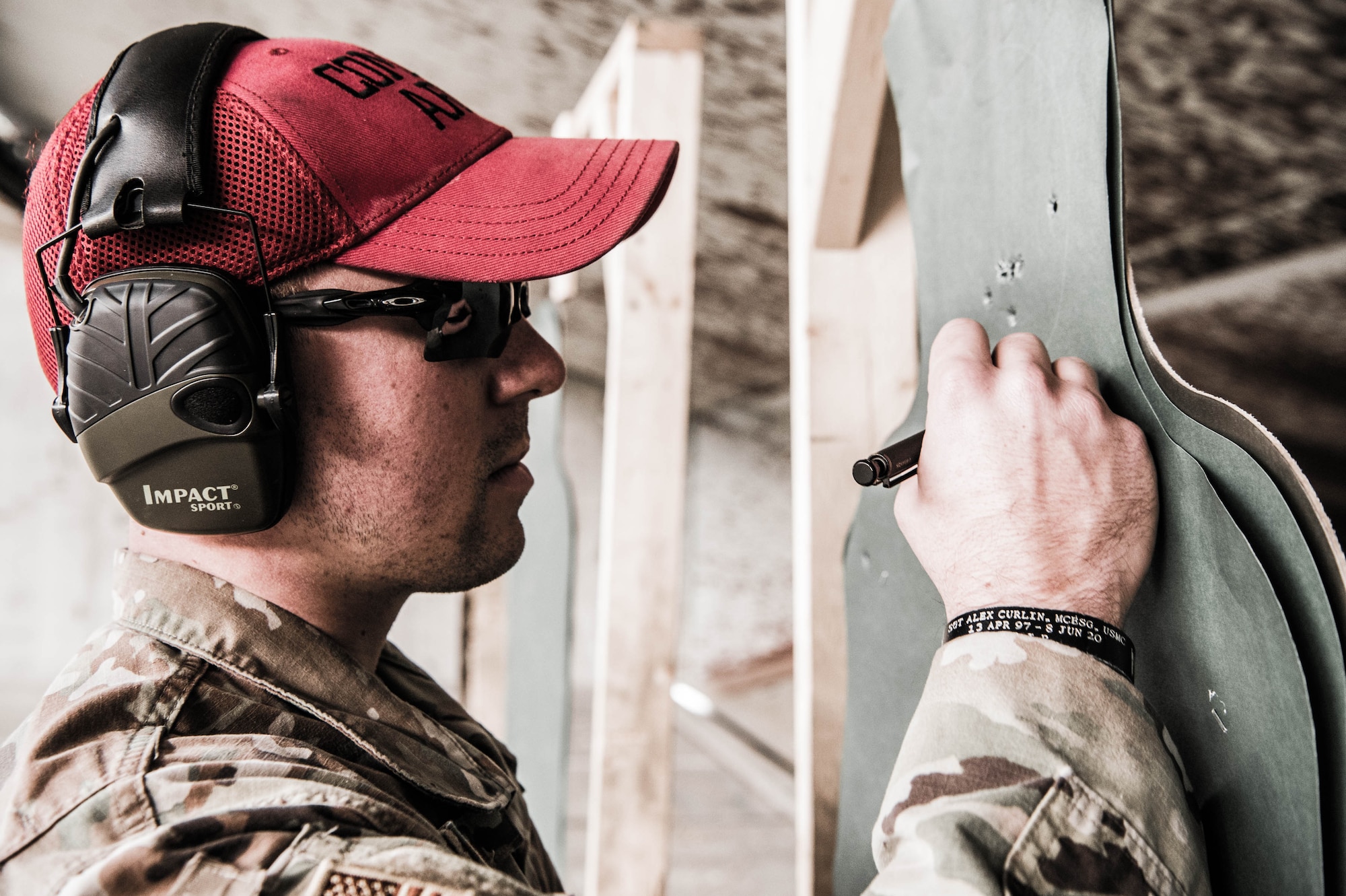 Staff Sgt. Christopher Keller, 436th Security Forces Squadron combat arms instructor, counts bullet holes on a target to determine a student’s combat arms qualification score Dec. 17, 2021, at Dover Air Force Base, Delaware. Students who fail qualification are offered additional instruction and another attempt to qualify. (U.S. Air Force photo by Mauricio Campino)