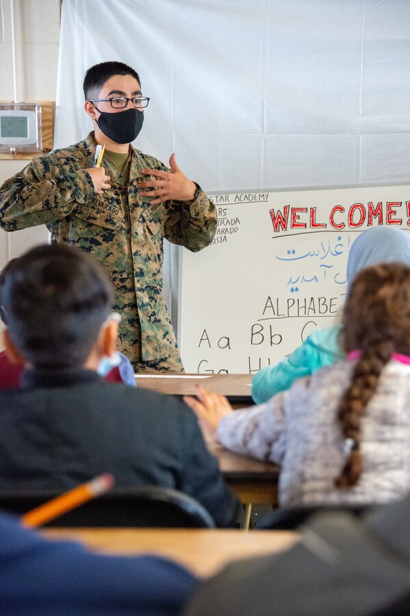 211229-N-YS140-013
Fort Pickett, Va. (Dec. 29, 2021) Lance Cpl. Ramiro Alvarado, administrative specialist, Charlie Company, 23rd Marine Regiment from Alamo, Texas instructs at Lonestar Academy, an educational facility that expands upon the curriculum already offered to Afghan evacuees. The Department of Defense, through U.S. Northern Command, and in support of the Department of Homeland Security, is providing transportation, temporary housing, medical screening, and general support for at least 50,000 Afghan evacuees at suitable facilities, in permanent or temporary structures, as quickly as possible. This initiative provides Afghan personnel essential support at secure locations outside Afghanistan. (U.S. Navy photo by Chief Mass Communication Specialist John Pearl)