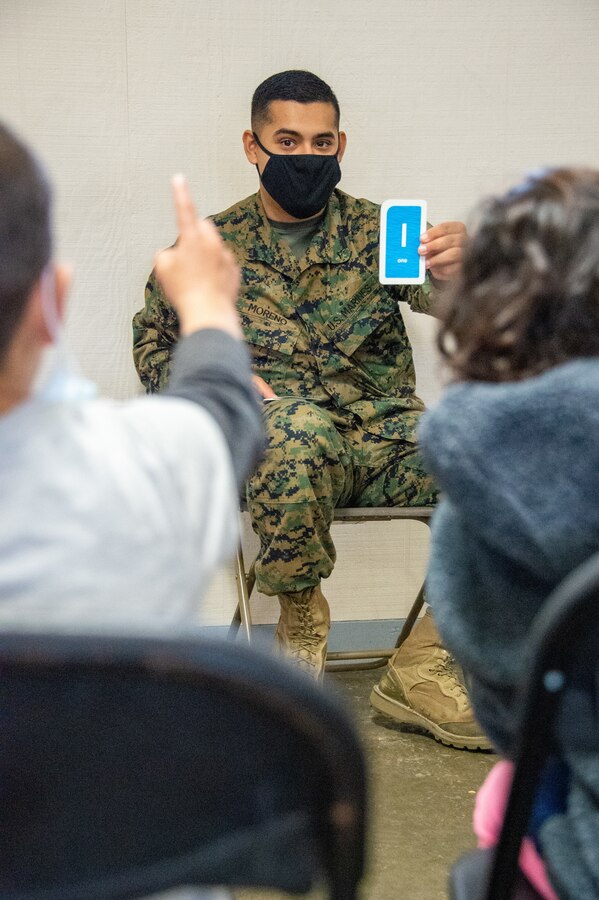 211229-N-YS140-032
Fort Pickett, Va. (Dec. 29, 2021) Lance Cpl. Adrian Moreno, rifleman, Alpha Company, 23rd Marine Regiment from Weslaco, Texas instructs at Lonestar Academy, an educational facility that expands upon the curriculum already offered to Afghan evacuees. The Department of Defense, through U.S. Northern Command, and in support of the Department of Homeland Security, is providing transportation, temporary housing, medical screening, and general support for at least 50,000 Afghan evacuees at suitable facilities, in permanent or temporary structures, as quickly as possible. This initiative provides Afghan personnel essential support at secure locations outside Afghanistan. (U.S. Navy photo by Chief Mass Communication Specialist John Pearl)
