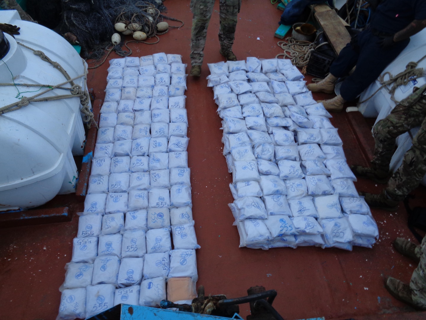 U.S. service members from coastal patrol ship USS Tempest (PC 2) and USS Typhoon (PC 5) inventory an illicit shipment of drugs while aboard a stateless dhow transiting international waters in the Arabian Sea, Dec. 27. (U.S. Navy photo)