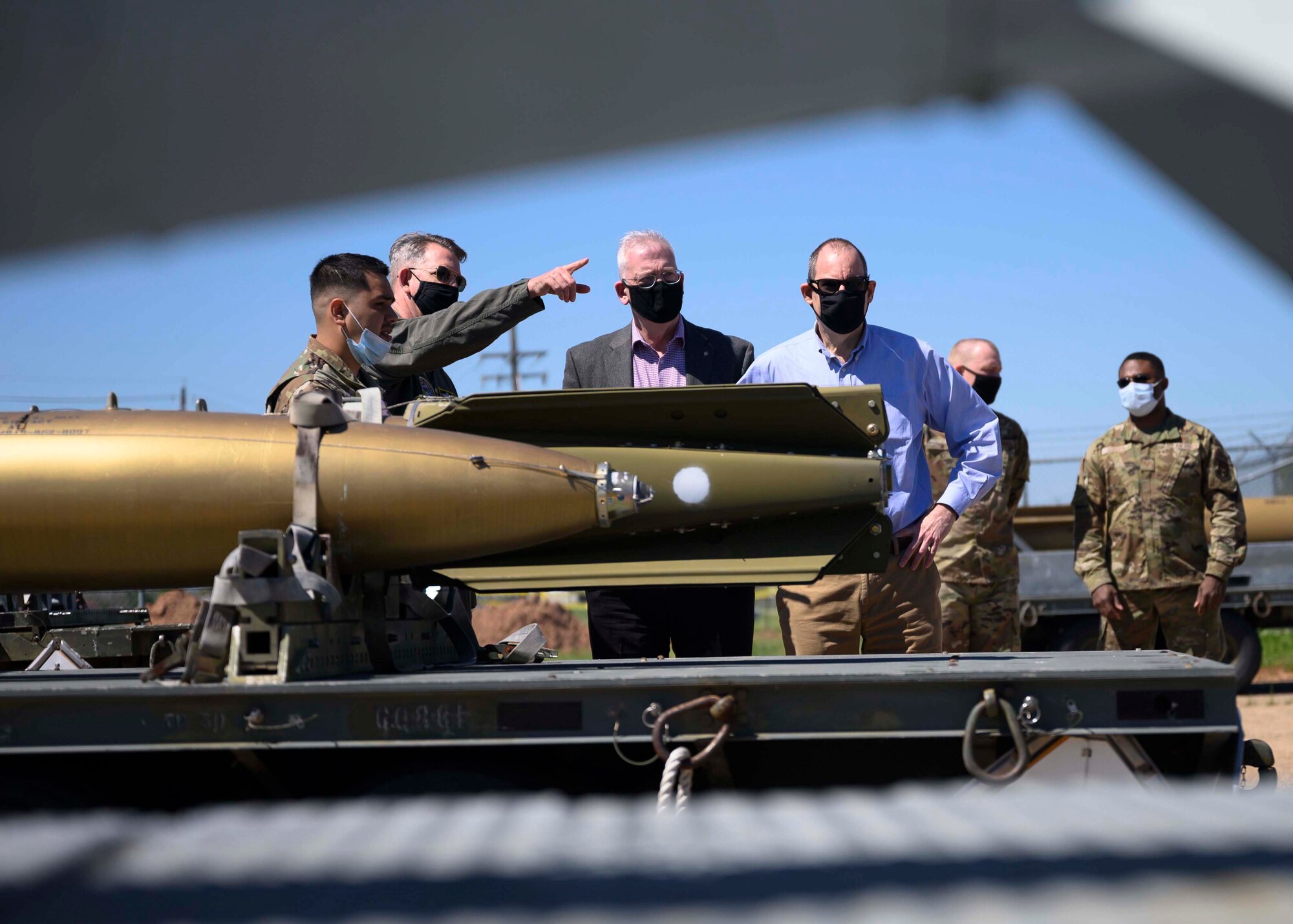 Photo of Airmen and civilians looking at various munitions.