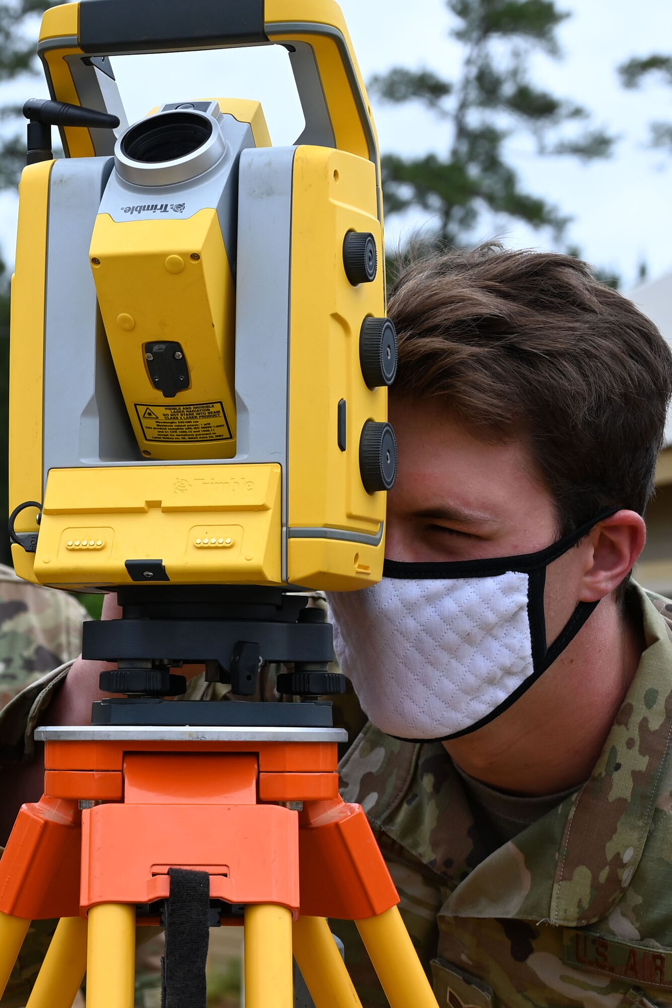 An Airman looks through a leveling device.