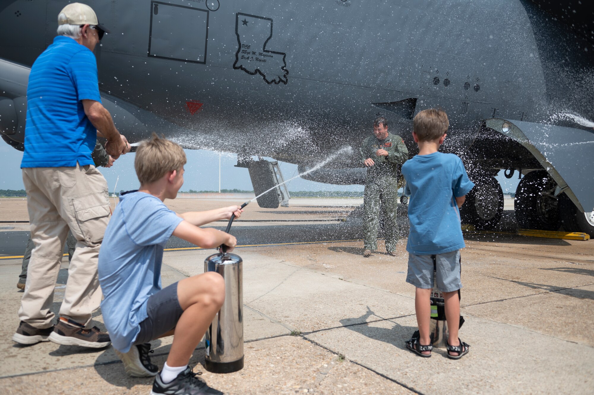 Photo of Airman being sprayed with water.