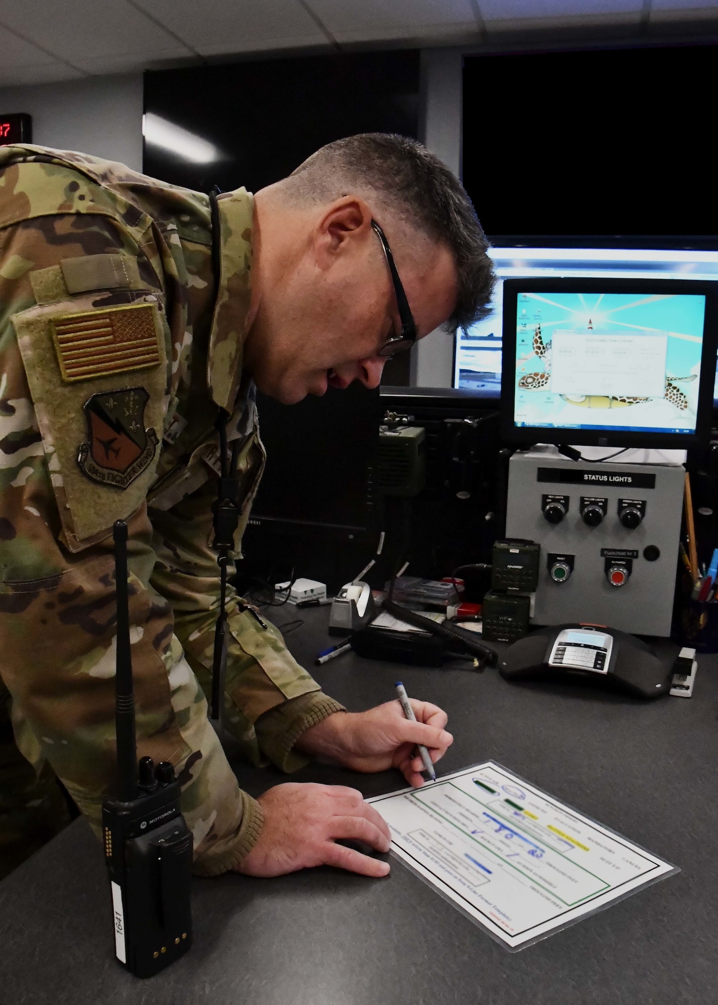 Master Sgt. Robert Ollquist, 104th Fighter Wing command post Non-commissioned Officer in Charge, copies information from higher headquarters in order to activate an appropriate response December 3, 2021, at Barnes Air National Guard Base, Massachusetts. The command post is responsible for receiving and dispersing all information coming onto or leaving Barnes ANGB.  (U.S. Air National Guard photo by Staff Sgt. Sara Kolinski)