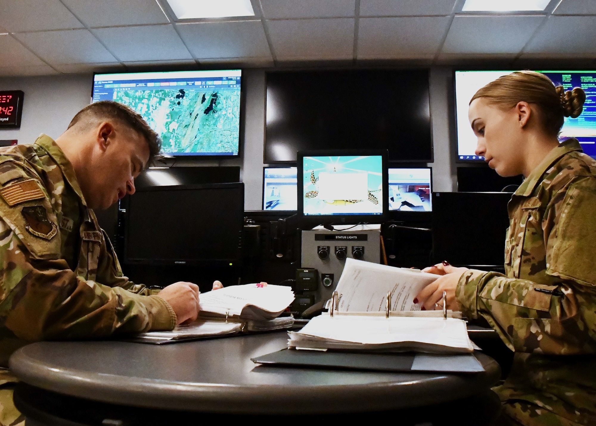 Master Sgt. Robert Ollquist, 104th Fighter Wing command post Non-commissioned Officer in Charge, and Staff Sgt. Chelsey Potter, 104th Fighter Wing command post controller, execute mission requirements December 3, 2021, at Barnes Air National Guard Base, Massachusetts. The command post is responsible for receiving and dispersing all information coming onto or leaving Barnes ANGB.  (U.S. Air National Guard photo by Staff Sgt. Sara Kolinski)