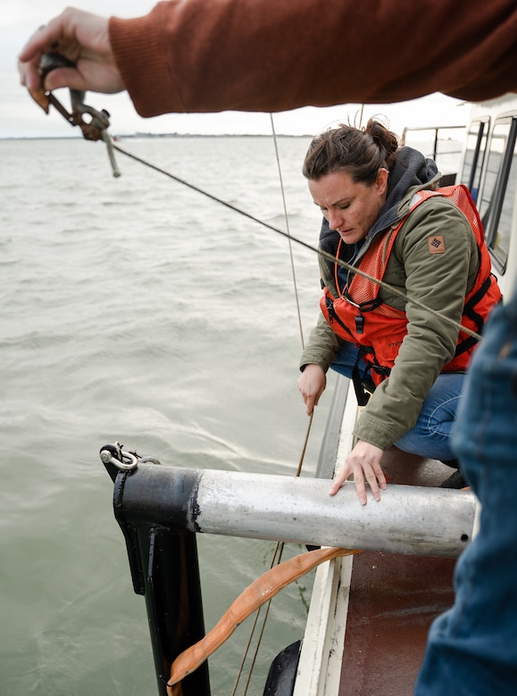 Sonja Zindars, a geographer with the U.S. Army Corps Of Engineers Charleston District, prepares to retrieve a Castaway CTD from the water. The device measures conductivity, temperature, and depth to determine a speed of sound change throughout the water column.