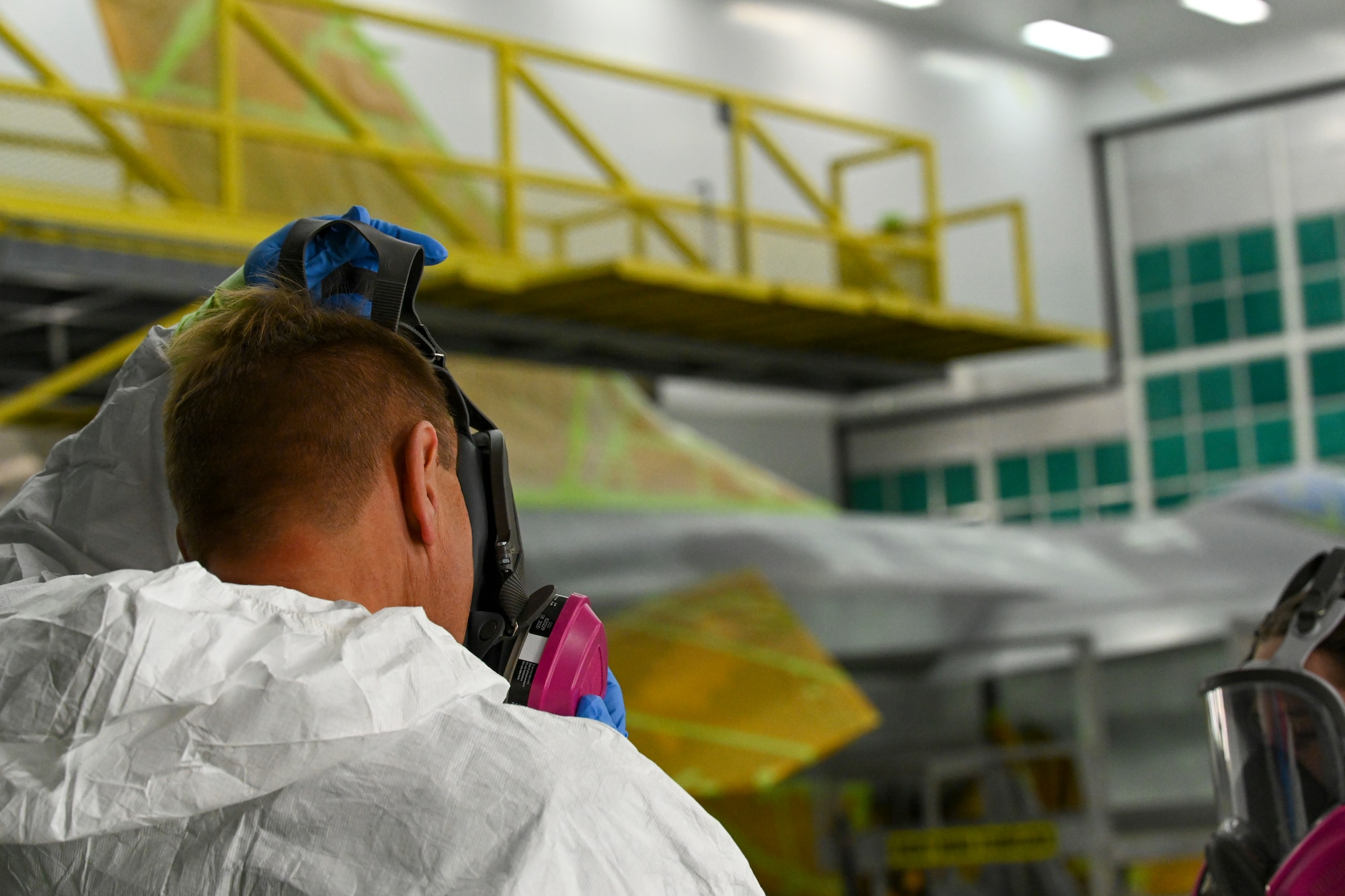 Col. Tom Preston, 49th Maintenance Group commander, dons a mask before painting stencil locations on a F-16 Viper, Dec. 9, 2021, on Holloman Air Force base, New Mexico. The newly painted F-16 is the 49th MXG’s first flagship and took about a month to complete. (U.S. Air Force photo by Airman 1st Class Adrian Salazar)