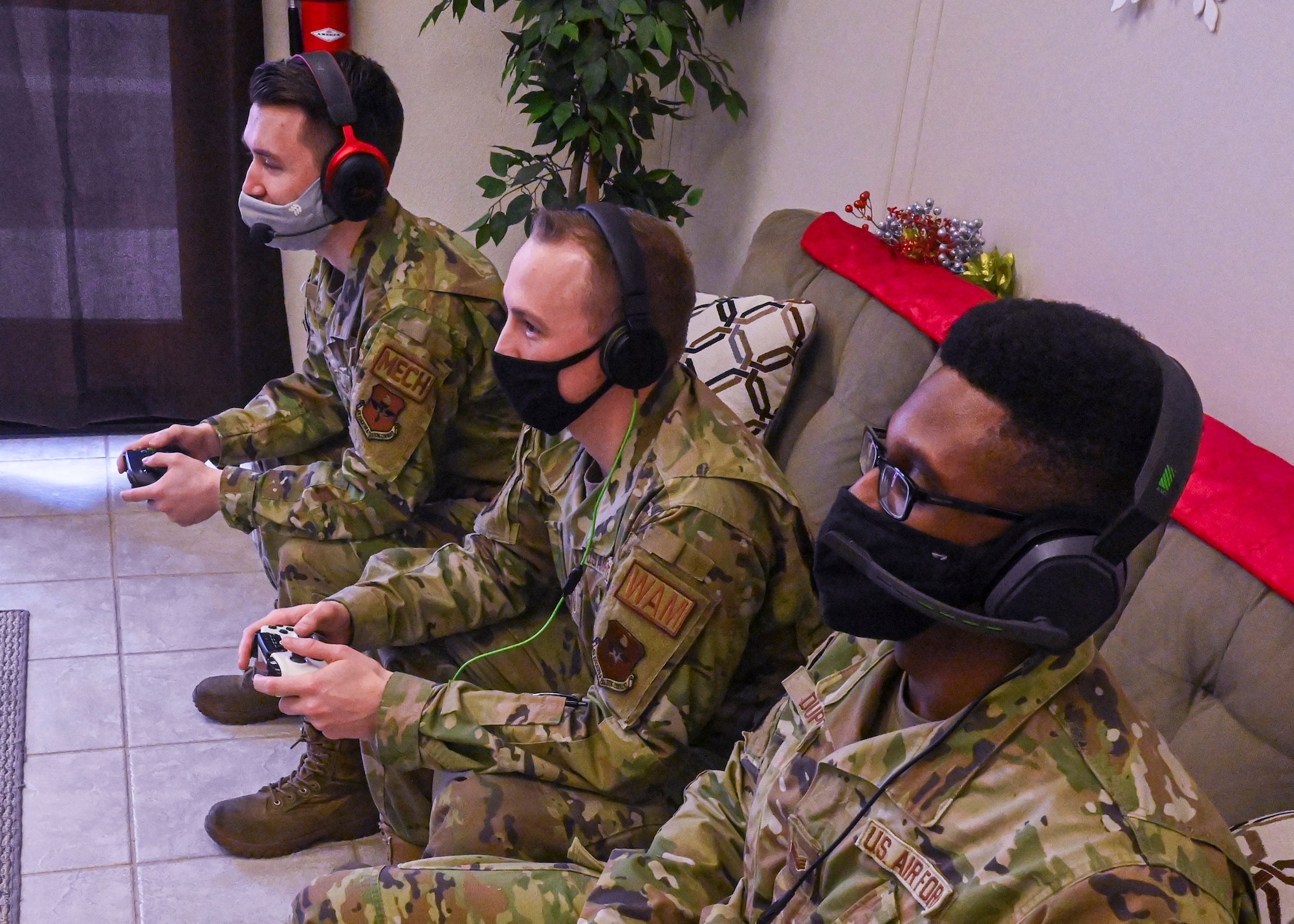 (Left to right) Senior Airman Isaac Garcia, 308th Aircraft Maintenance Unit assistant dedicated crew chief, Master Sgt. Joseph Blahut, 56th Maintenance Group wing avionics manager, and Senior Airman Jeffrey Dupont, 308th AMU autonomic logistics information system expeditor, play a video game together Dec. 14, 2021 at Luke Air Force Base, Arizona. Their team, “Joint Strike Fighters,” is competing in the Department of the Air Force Gaming League’s Apex Legends Tournament, which aims to bolster morale within participating units and build connections beyond Luke AFB. (U.S. Air Force photo by Senior Airman David Busby.)