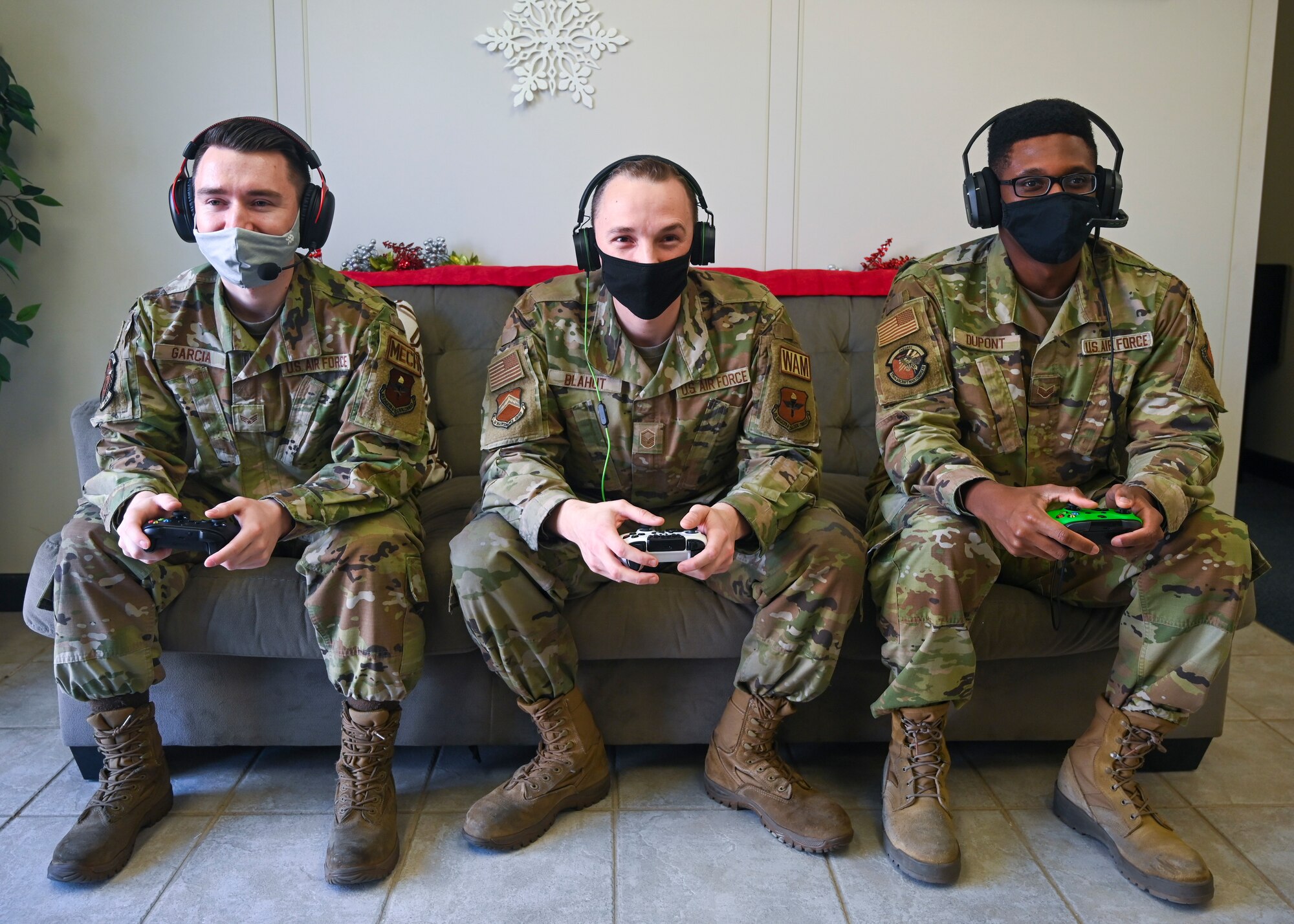 (Left to right) Senior Airman Isaac Garcia, 308th Aircraft Maintenance Unit assistant dedicated crew chief, Master Sgt. Joseph Blahut, 56th Maintenance Group wing avionics manager, and Senior Airman Jeffrey Dupont, 308th AMU autonomic logistics information system expeditor, play a video game together Dec. 14, 2021, at Luke Air Force Base, Arizona. The Airmen make up a team they call “Joint Strike Fighters” in the Department of the Air Force Gaming League’s Apex Legends Tournament. Over 400 service members have competed in the tournament across the Air Force, which aims to strengthen teamwork and morale. (U.S. Air Force photo by Senior Airman David Busby.)