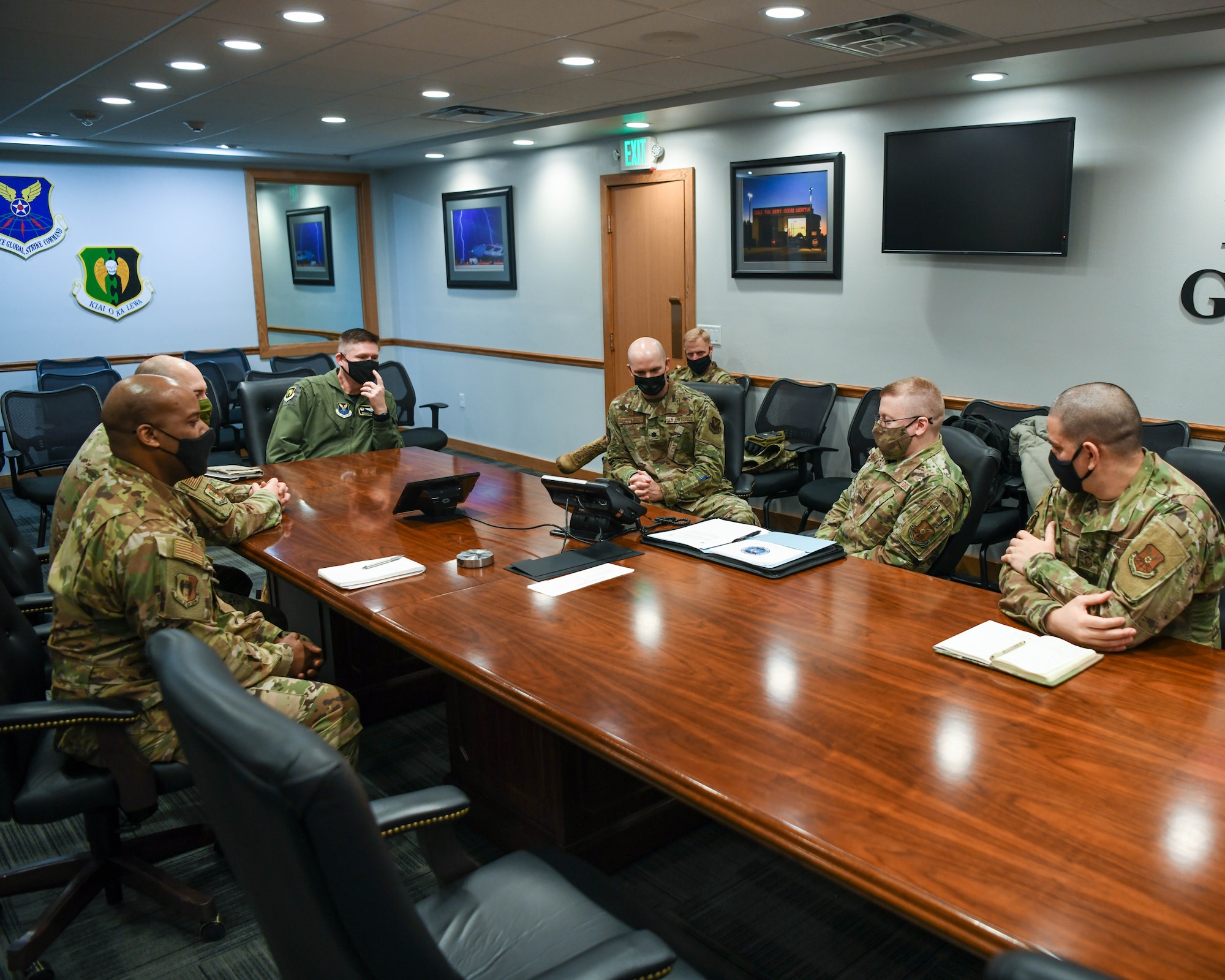Staff Sgt. Banta sits around a conference room table with 5th Bomb Wing leadership