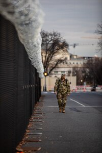 A U.S. Soldier with the National Guard, examines a perimeter fence outside the U.S. Capitol in Washington, D.C.