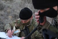 soldier writes on papers in the field
