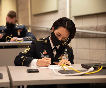 1st Sgt. Tina Semanoff, company first sergeant for Headquarters and Headquarters Detachment, 97th Troop Command, takes a  written exam during the Utah National Guard Best Warrior Competition