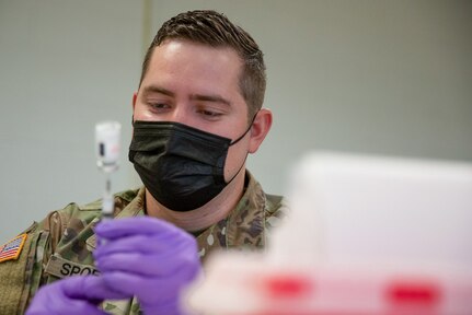 A medical soldier prepares a COVID-19 vaccine