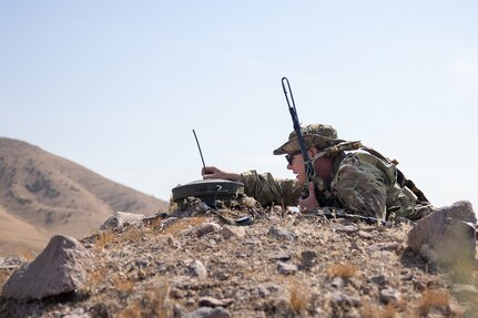 A soldier prepares a low level audio interception device on top of a hil