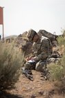 Soldier sits on ground and writes in notebook