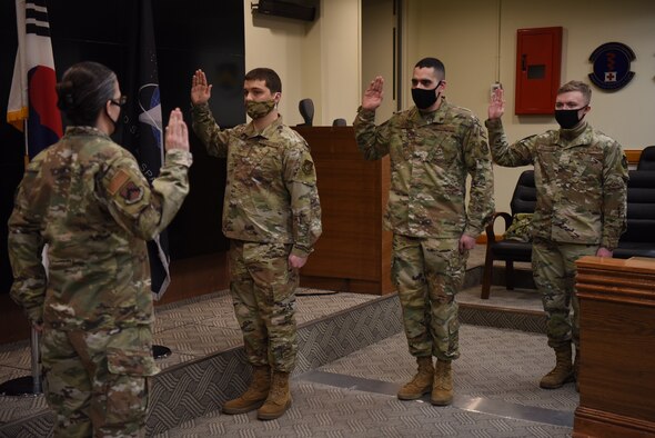 Colonel Jennifer Phelps, 8th Mission Support Group commander, delivers the oath of enlistment to Airman 1st Class Anton Soloshenko, Airman 1st Class Emmanuel Londono, and Airman Nickolai Patchin, in the 8th Fighter Wing conference room at Kunsan Air Base, Republic of Korea, Feb. 1, 2021.