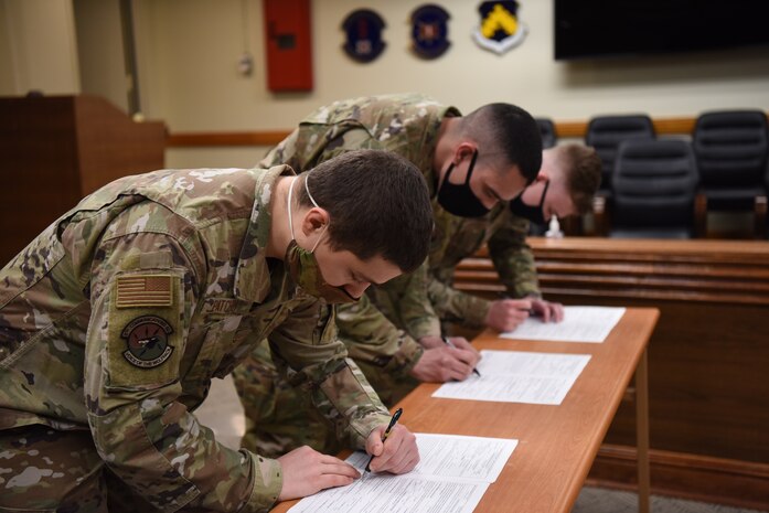 Airman 1st Class Anton Soloshenko, Airman 1st Class Emmanuel Londono, and Airman Nickolai Patchin sign U.S. Space Force paperwork at Kunsan Air Base, Republic of Korea, Feb, 1, 2021.