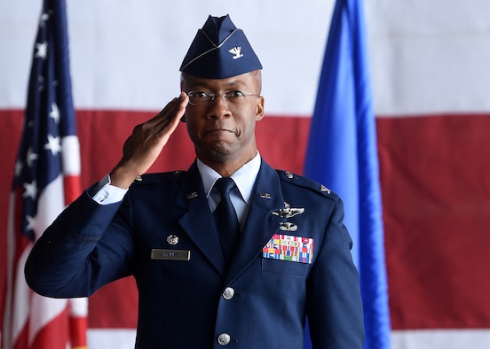 African American man in blue Air Force service dress uniform holds hand in salute position with