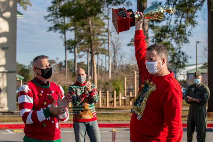 U.S. Marine Corps Col. Curtis V. Ebitz, left, commanding officer of Marine Corps Air Station New River, claps as Lt. Col. Thomas J. Dunn, right, the Personnel Studies and Oversight commanding officer for Marine Aircraft Group 26 raises the Commander’s Cup at the MAG-26 headquarters building on MCAS New River, Dec. 18, 2020. Units competed in a series of different sporting events and tournaments, each winning unit was awarded with a Commanders’ Cup trophy and monetary compensation in the form of unit and Family Readiness funds. (U.S. Marine Corps Photo by Lance Cpl. Isaiah Gomez)