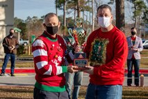 U.S. Marine Corps Col. Curtis V. Ebitz, left, commanding officer of Marine Corps Air Station New River, and Lt. Col. Thomas J. Dunn, right, the Personnel Studies and Oversight commanding officer for Marine Aircraft Group 26, pose for a photo with the Commander’s Cup at the MAG-26 headquarters building on MCAS New River, Dec. 18, 2020. Units competed in a series of different sporting events and tournaments, each winning unit was awarded with a Commanders’ Cup trophy and monetary compensation in the form of unit and Family Readiness funds. (U.S. Marine Corps Photo by Lance Cpl. Isaiah Gomez)