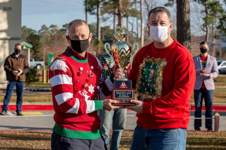 U.S. Marine Corps Col. Curtis V. Ebitz, left, commanding officer of Marine Corps Air Station New River, and Lt. Col. Thomas J. Dunn, right, the Personnel Studies and Oversight commanding officer for Marine Aircraft Group 26, pose for a photo with the Commander’s Cup at the MAG-26 headquarters building on MCAS New River, Dec. 18, 2020. Units competed in a series of different sporting events and tournaments, each winning unit was awarded with a Commanders’ Cup trophy and monetary compensation in the form of unit and Family Readiness funds. (U.S. Marine Corps Photo by Lance Cpl. Isaiah Gomez)