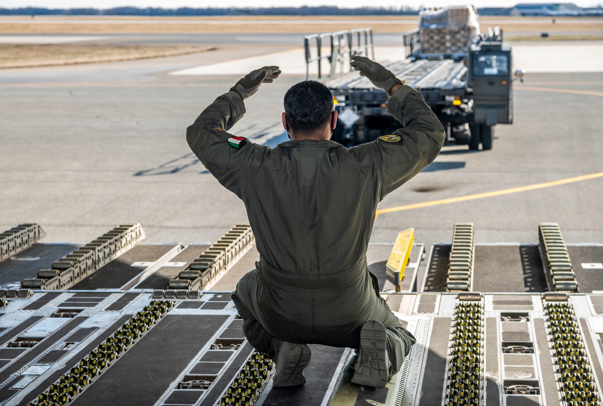 A Kuwait air force airman guides a K-loader toward the ramp of a Kuwait air force C-17 Globemaster III at Dover Air Force Base, Delaware, Jan. 22, 2021. The U.S. strongly supports Kuwait’s sovereignty, security and independence as well as its multilateral diplomatic efforts to build greater cooperation in the region. Due to its strategic geographic location, Dover AFB supports approximately $3.5 billion worth of foreign military sales operations annually. (U.S. Air Force photo by Senior Airman Christopher Quail)