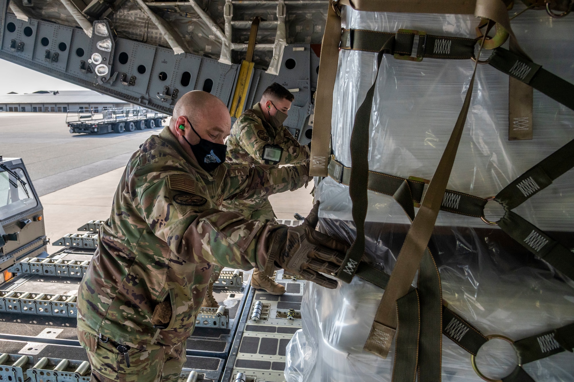 Airmen from the 436th Aerial Port Squadron move cargo onto a Kuwait air force C-17 Globemaster III at Dover Air Force Base, Delaware, Jan. 22, 2021. Kuwait is an important partner in U.S. counterterrorism efforts, providing assistance in the military, diplomatic, and intelligence arenas and also supporting efforts to block financing of terrorist groups. Due to its strategic geographic location, Dover AFB supports approximately $3.5 billion worth of foreign military sales operations annually. (U.S. Air Force photo by Senior Airman Christopher Quail) (This image was altered for security purposes by blurring identification badges)