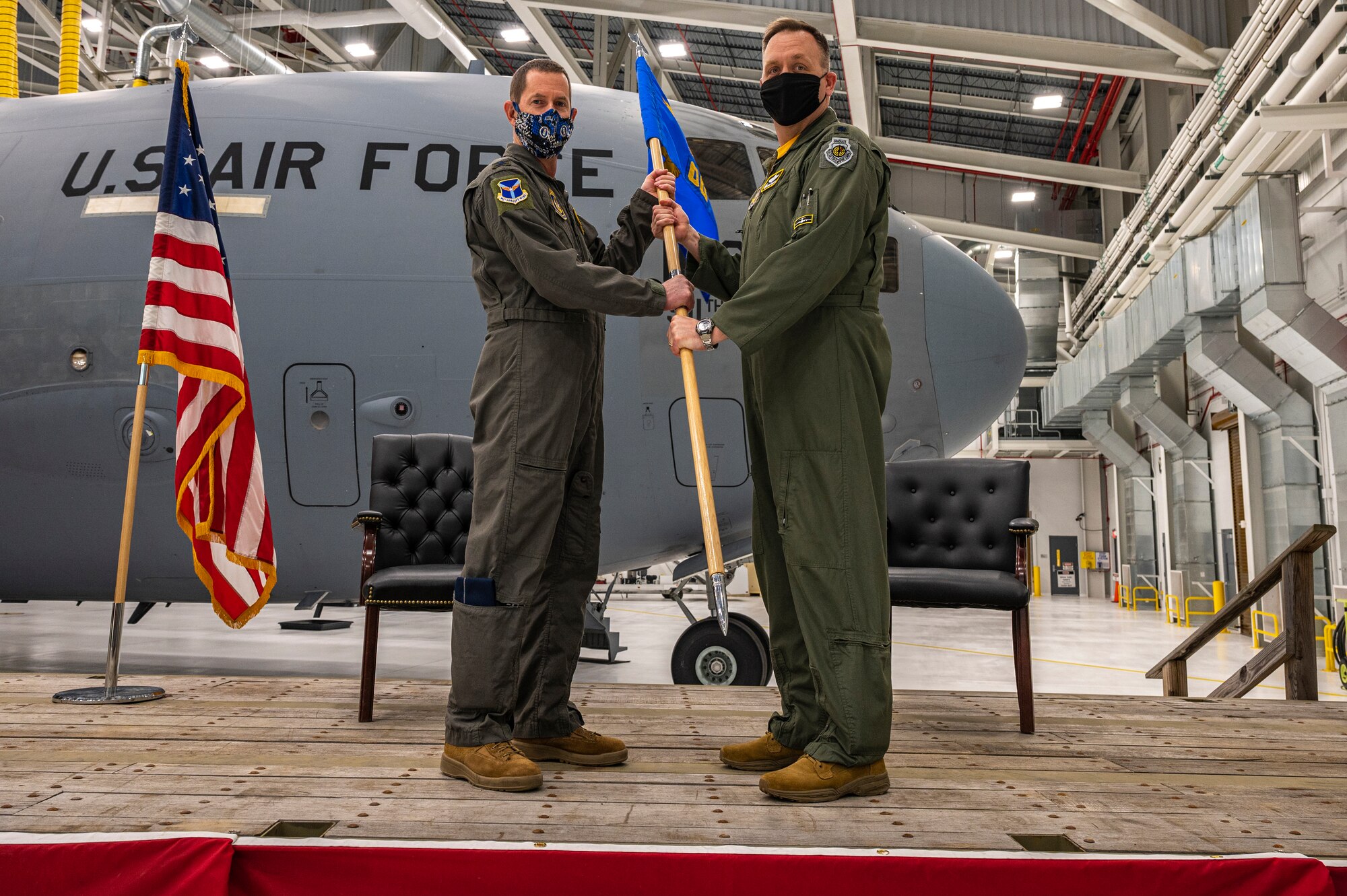 Col. John Robinson, 911th Airlift Wing commander, passes a guidon to incoming 911th Operations Group Commander Lt. Col. Bryan Bailey, at the Pittsburgh International Airport Air Reserve Station, Pennsylvania, Jan. 10, 2021.