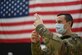 U.S. Air Force Capt. Alexander Godwin constitutes a vial in front of an American flag.