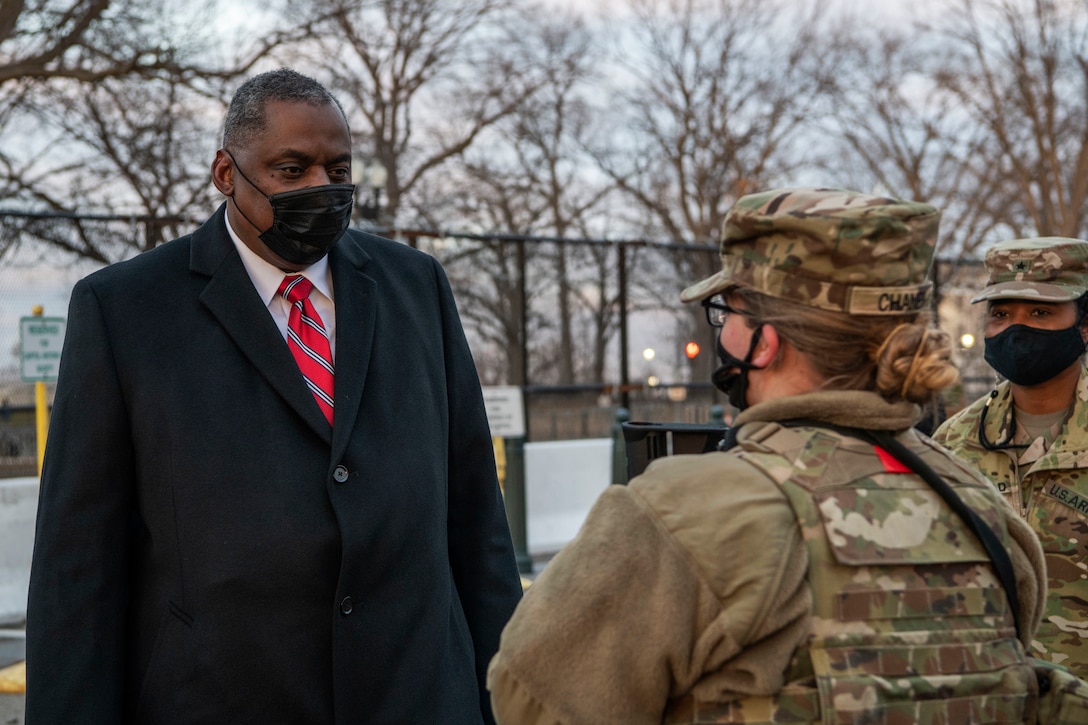 Secretary of Defense Lloyd J. Austin III speaks with a member of the National Guard.