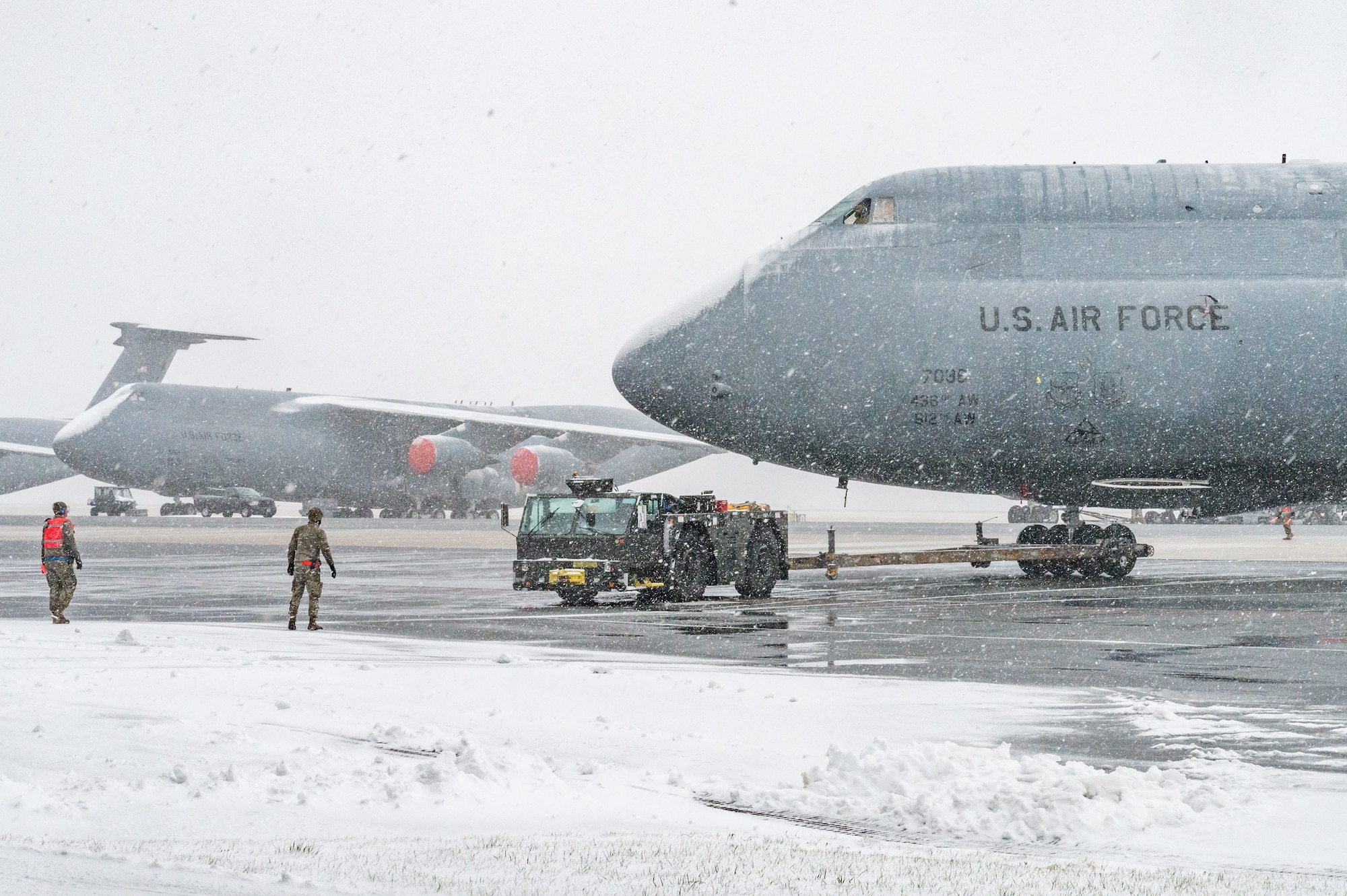Maintainers from the 436th Aircraft Maintenance Squadron tow a C-5M Super Galaxy from the flight line to a hangar for maintenance at Dover Air Force Base, Delaware, Jan. 31, 2021. Despite a prolonged nor’easter, the base maintained normal operations and prepared for additional snowfall. (U.S. Air Force photo by Roland Balik)