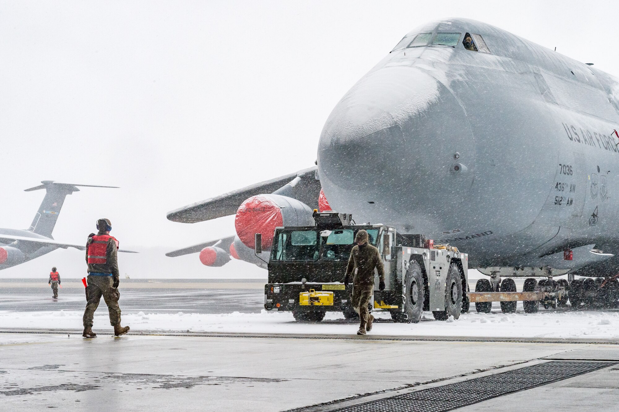 Maintainers from the 436th Aircraft Maintenance Squadron tow a C-5M Super Galaxy from the flight line to a hangar for maintenance at Dover Air Force Base, Delaware, Jan. 31, 2021. Despite a prolonged nor’easter, the base maintained normal operations and prepared for additional snowfall. (U.S. Air Force photo by Roland Balik)