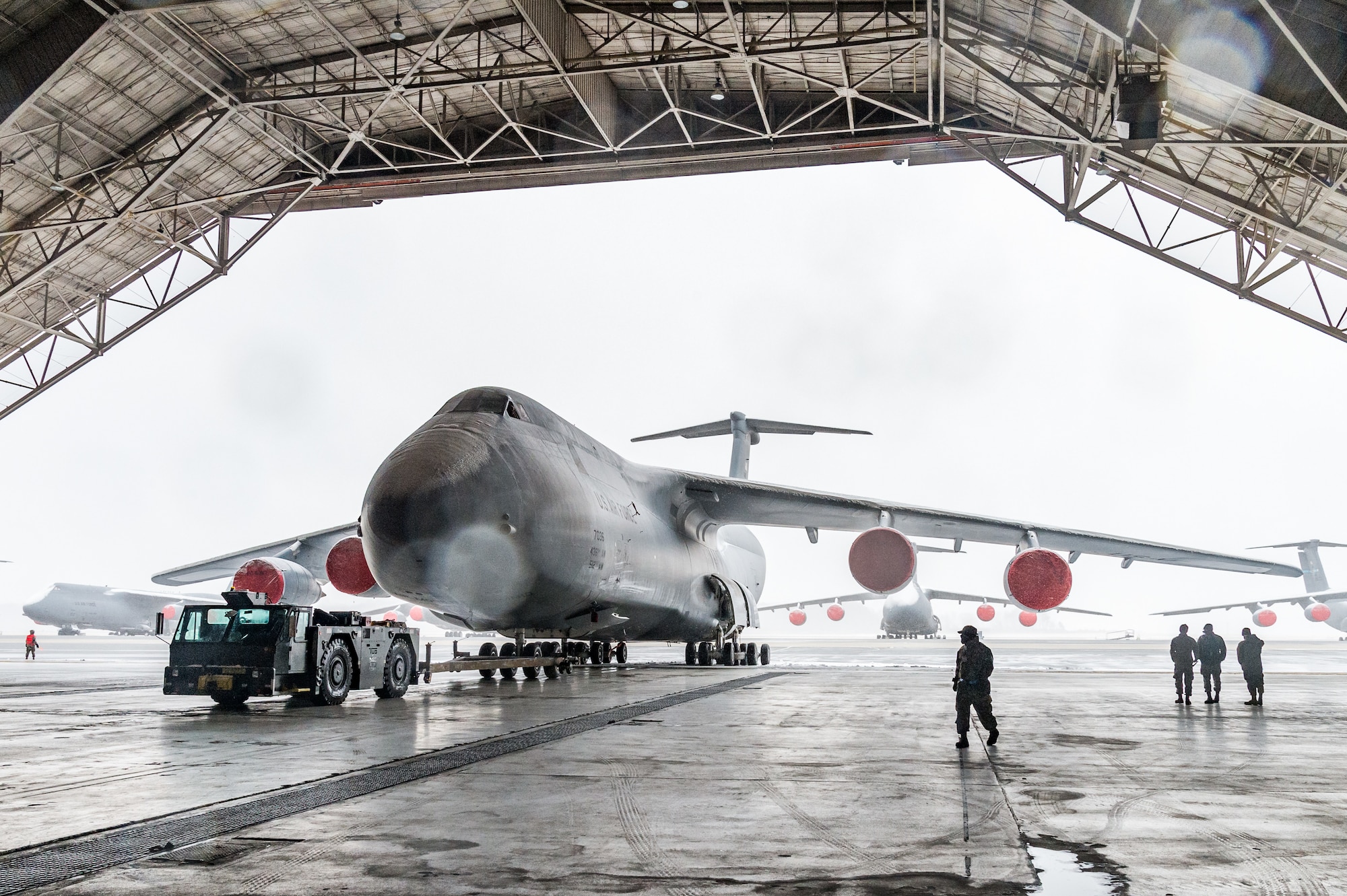 Maintainers from the 436th Aircraft Maintenance Squadron tow a C-5M Super Galaxy from the flight line to a hangar for maintenance at Dover Air Force Base, Delaware, Jan. 31, 2021. Despite a prolonged nor’easter, the base maintained normal operations and prepared for additional snowfall. (U.S. Air Force photo by Roland Balik)
