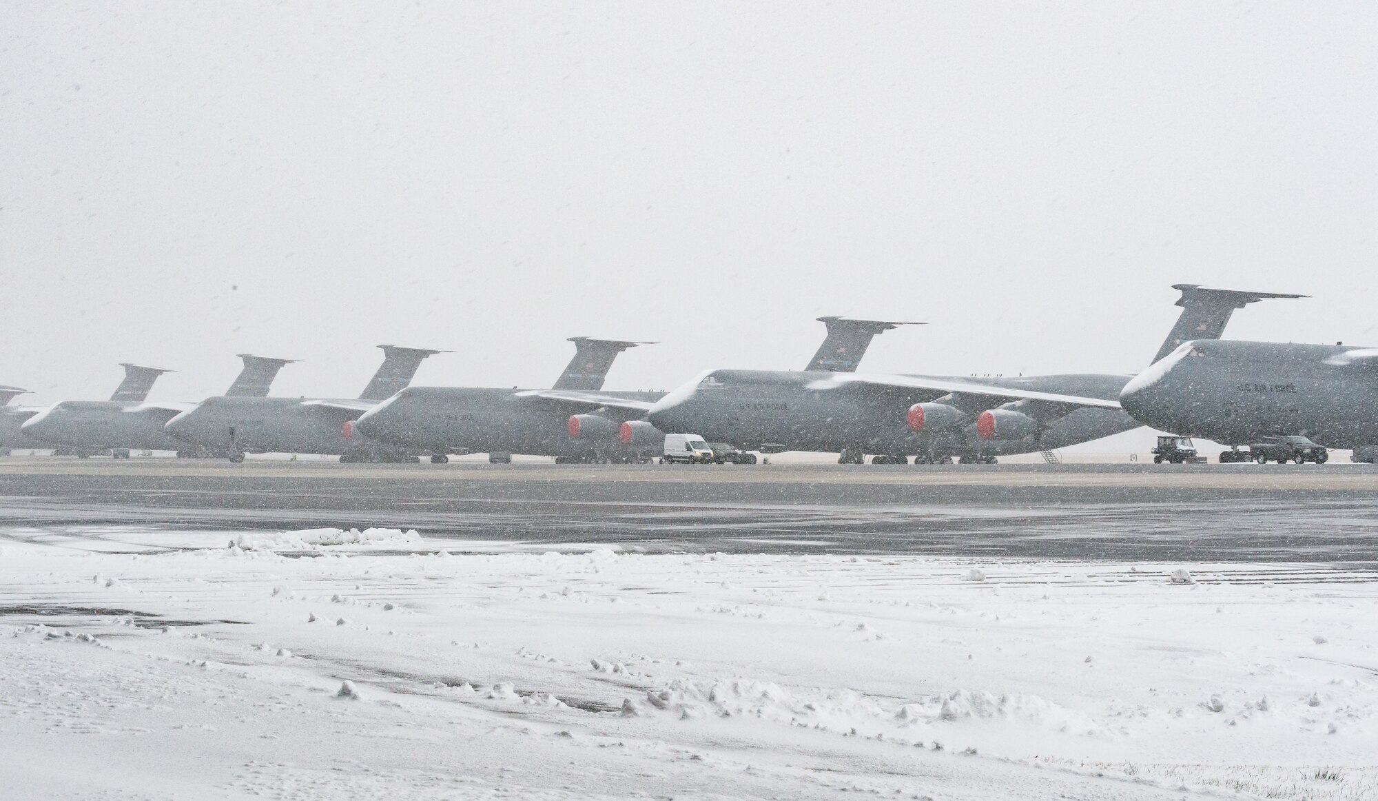 Airmen from the 436th Airlift Wing prepare C-5M Super Galaxies for a snow and rain mixture at Dover Air Force Base, Delaware, Jan. 31, 2021. Despite a prolonged nor’easter, the base maintained normal operations and prepared for additional snowfall. (U.S. Air Force photo by Roland Balik)
