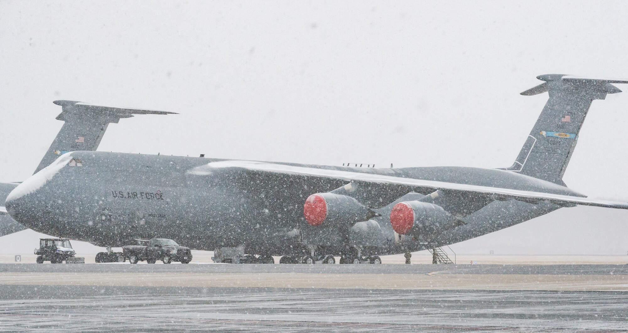 Airmen from the 436th Airlift Wing prepare a C-5M Super Galaxy for a snow and rain mixture at Dover Air Force Base, Delaware, Jan. 31, 2021. Despite a prolonged nor’easter, the base maintained normal operations and prepared for additional snowfall. (U.S. Air Force photo by Roland Balik)