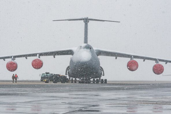 Maintainers from the 436th Aircraft Maintenance Squadron tow a C-5M Super Galaxy from the flight line to a hangar for maintenance at Dover Air Force Base, Delaware, Jan. 31, 2021. Despite a prolonged nor’easter, the base maintained normal operations and prepared for additional snowfall. (U.S. Air Force photo by Roland Balik)