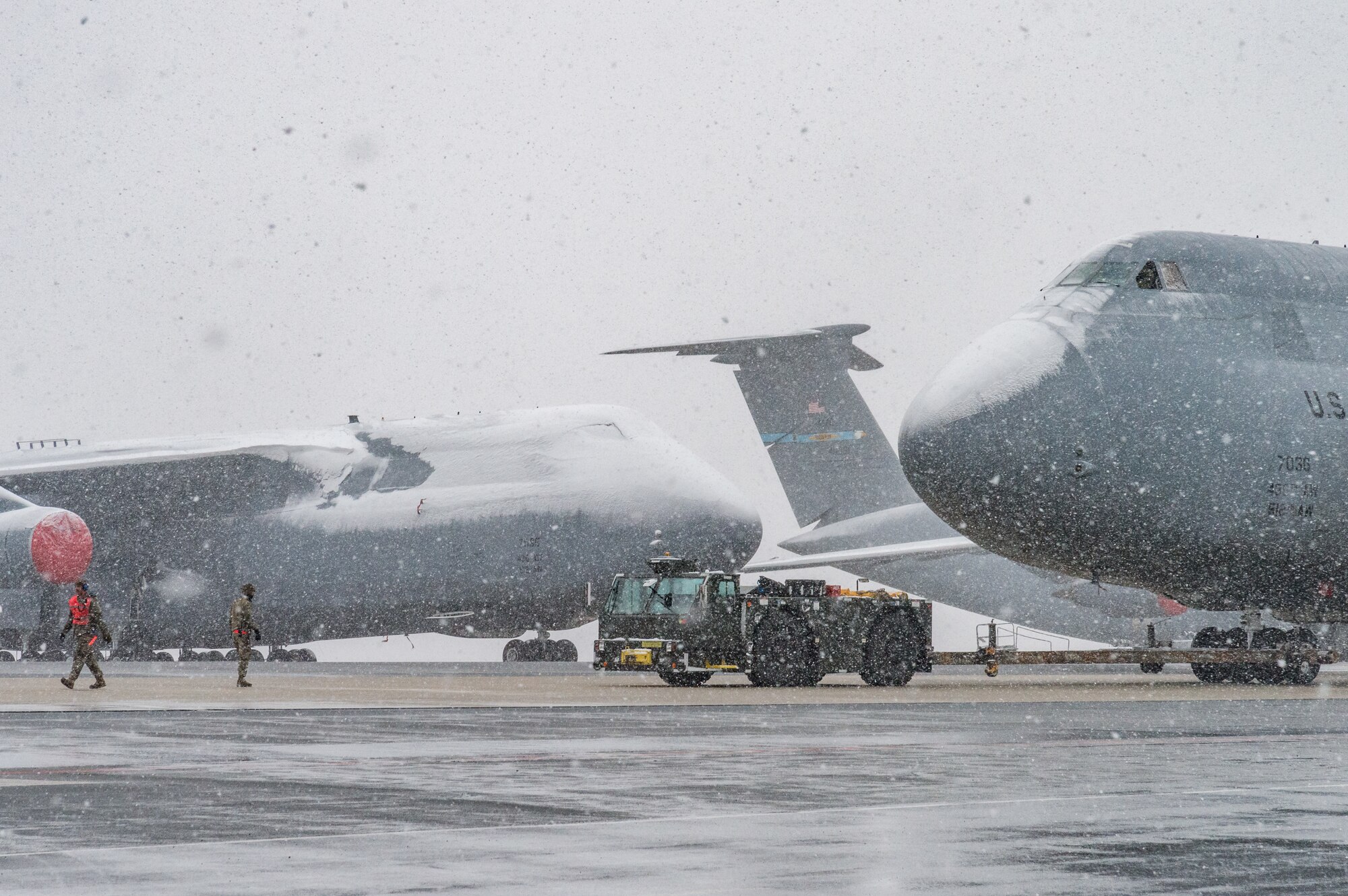 Maintainers from the 436th Aircraft Maintenance Squadron tow a C-5M Super Galaxy from the flight line to a hangar for maintenance at Dover Air Force Base, Delaware, Jan. 31, 2021. Despite a prolonged nor’easter, the base maintained normal operations and prepared for additional snowfall. (U.S. Air Force photo by Roland Balik)