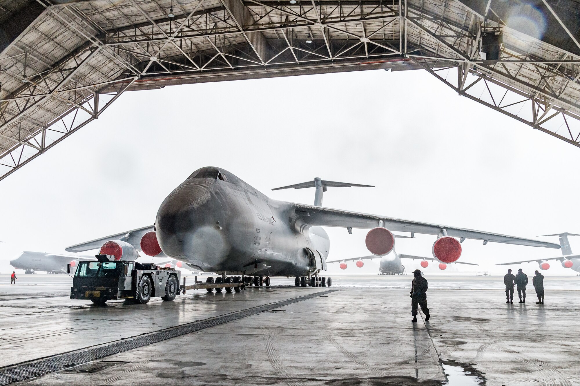 Maintainers from the 436th Aircraft Maintenance Squadron tow a C-5M Super Galaxy from the flight line to a hangar for maintenance at Dover Air Force Base, Delaware, Jan. 31, 2021. Despite a prolonged nor’easter, the base maintained normal operations and prepared for additional snowfall. (U.S. Air Force photo by Roland Balik)