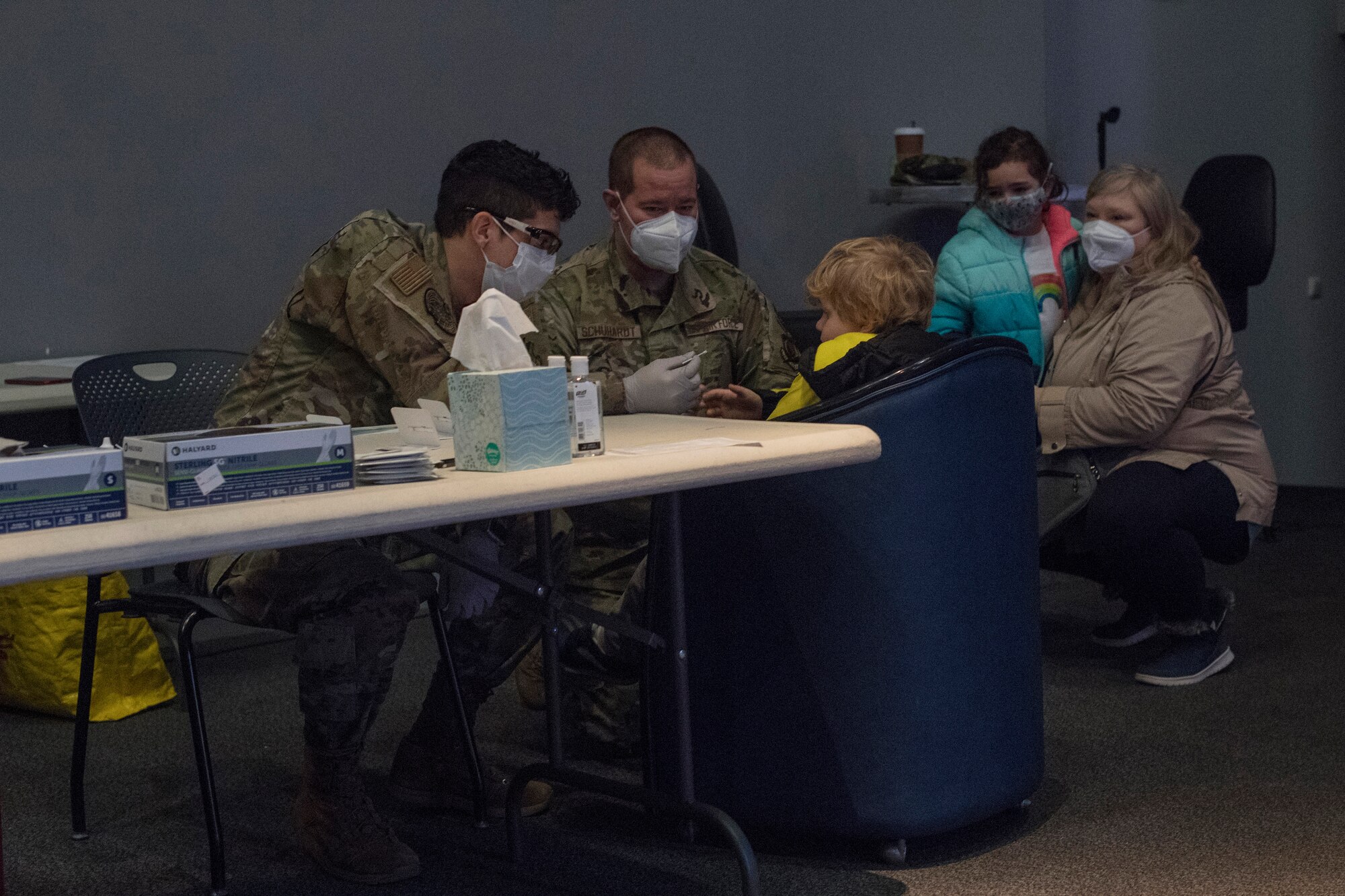 U.S. Air Force Senior Airman Marquis Barney, 86th Healthcare Operations Squadron medical technician, left, conducts pre-travel COVID-19 testing on Senior Master Sgt. Jacob Schuhardt, 86th Airlift Wing safety superintendent, and Schuhardt’s family, at the Enlisted Club on Ramstein Air Base, Germany, Jan. 28, 2021.