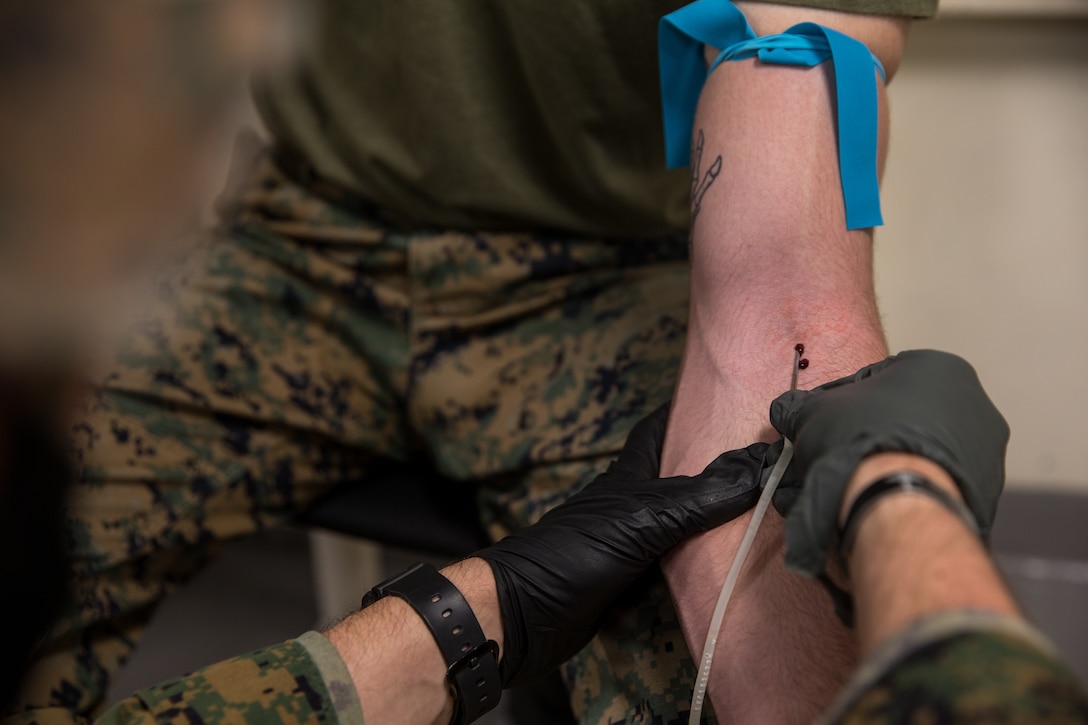 A U.S. Navy Hospital Corpsman establishes a connection line into a U.S. Marine during Valkyrie emergency fresh whole blood transfusion training aboard the amphibious transport dock ship USS Somerset (LPD 25), Dec. 22.