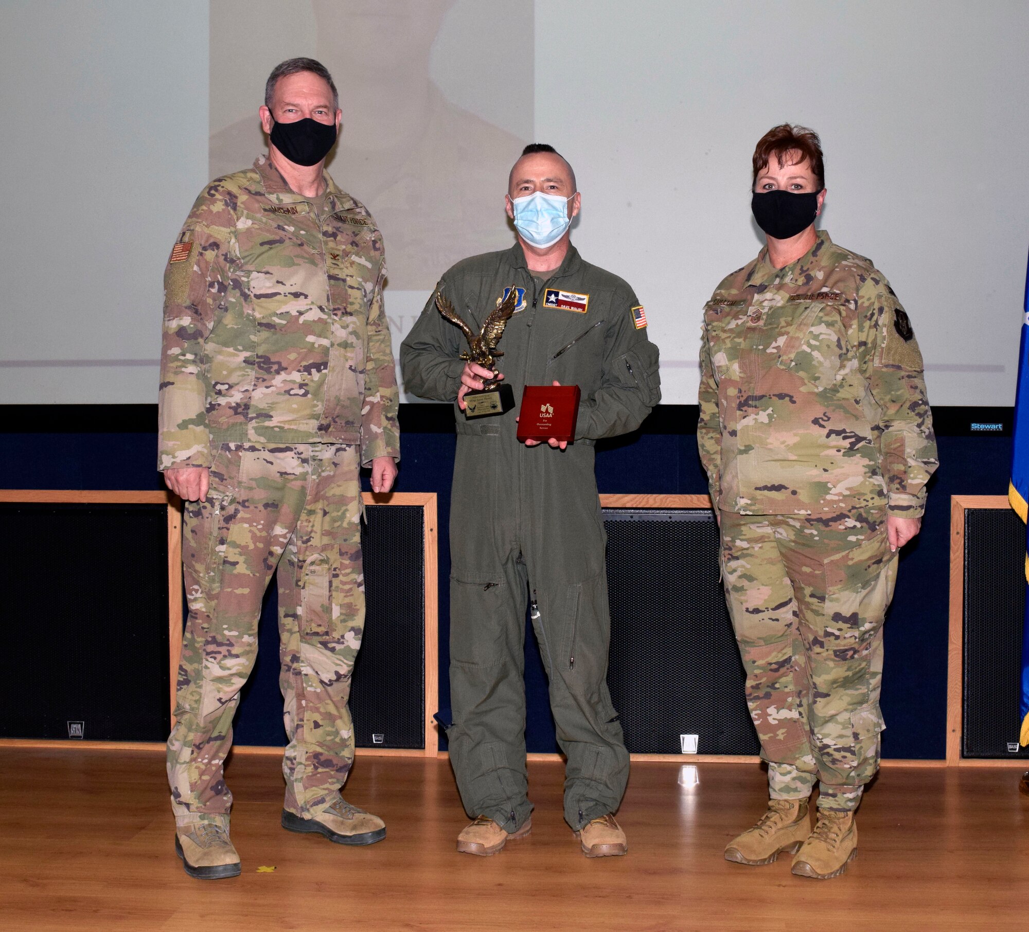 Chief Master Sgt. David J Walsh, 433rd Operations Group (center), accepts the senior noncommissioned officer category award from Col. Terry W. McClain, 433rd Airlift Wing commander, and Chief Master Sgt. Shana C. Cullum, 433rd AW command chief, on behalf of the winner, Master Sgt. Jason Henry, 733rd Training Squadron, during the wing’s annual award recognition ceremony Jan. 30, 2021 at Joint Base San Antonio-Lackland, Texas. Henry was unable to attend the ceremony. (U.S. Air Force photo by Airman 1st Class Brittany K. Wich)
