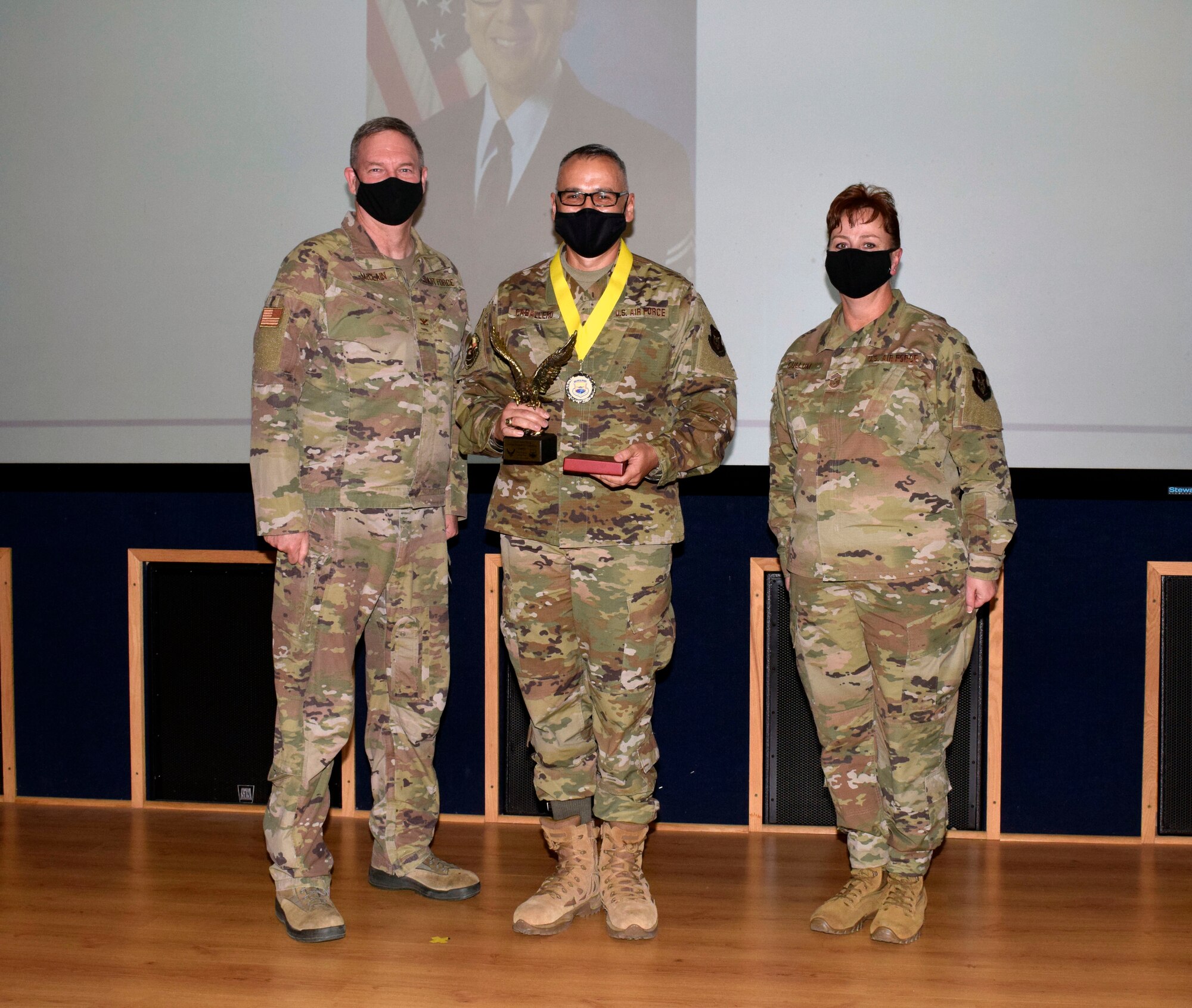 Col. Terry W. McClain, 433rd Airlift Wing commander, and Chief Master Sgt. Shana C. Cullum, 433rd AW command chief, stand to the sides of first sergeant category winner, Senior Master Sgt. Samuel G. Caballero Jr., 26th Aerial Port Squadron, at the wing’s annual award recognition ceremony Jan. 30, 2021 at Joint Base San Antonio-Lackland, Texas. (U.S. Air Force photo by Airman 1st Class Brittany K. Wich)